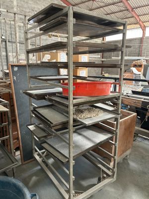 un présentoir métallique sur lequel sont disposés plusieurs plateaux de nourriture