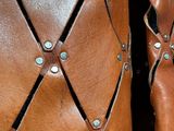 close up of a pair of brown leather boots with rivets on them