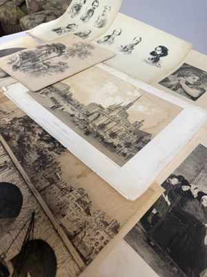 de nombreuses vieilles photos posées sur une table, à côté d'une paire de ciseaux