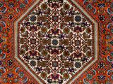 an orange and blue rug with a medallion design on it