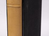 un livre noir et or posé sur une table blanche