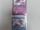 two pokemon cards sitting on top of each other on a table