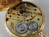 a gold pocket watch with gears and a clock inside of it