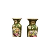 une paire de vases verts ornés de motifs floraux sur fond blanc