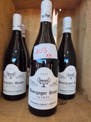 trois bouteilles de vin rouge sont posées dans une caisse en bois