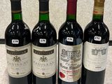 Quatre bouteilles de vin sont alignées sur un plan de travail