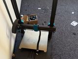 une imprimante 3D posée par terre