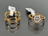 two gold and silver rings with diamonds on a black surface