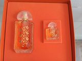 une boîte orange contenant deux flacons de parfum et un petit flacon de parfum