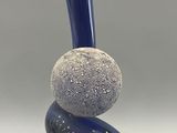 a blue vase that has two rocks on top of it