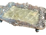 a silver tray with a green glass in it