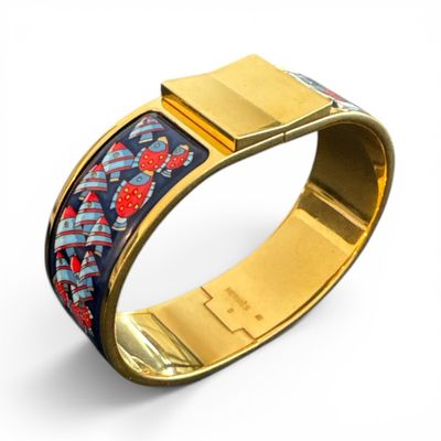 a close up of a gold bracelet with a blue and red design on it