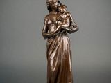a bronze statue of a woman holding a child