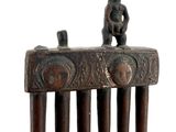 a wooden comb that has a small animal on top of it