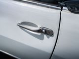 a close up of a door handle on a white car