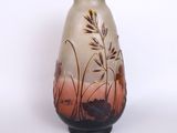 a vase that has a picture of a field of grass on it