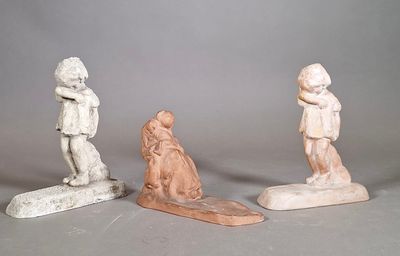 trois petites statues représentant un garçon et une fille sur une planche de surf