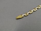 an image of a yellow gold chain with diamonds on a gray surface
