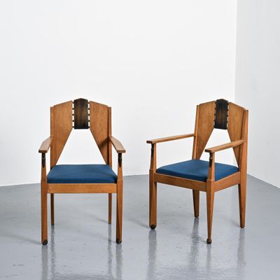 deux chaises en bois avec des coussins rembourrés bleus dans une pièce blanche