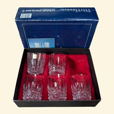 quatre verres dans une boîte contenant un tissu rouge