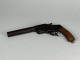 an old gun with a wooden handle on a white surface