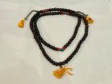 un gros plan sur un collier en perles orné d'un pompon