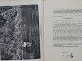 an open book with a black and white photo of a person on a rock