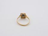a gold ring with a blue stone in the center