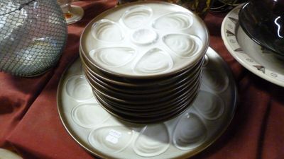 une pile d'assiettes posée sur une table, avec un vase en arrière-plan