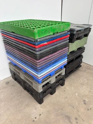 a lot of different colored plastic pallets stacked on top of each other