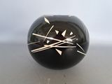 a black vase with white lines on it sitting on a table