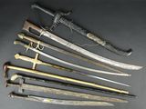 several different types of swords are displayed on a black surface
