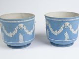 pair of blue and white vases with designs on them on a white surface