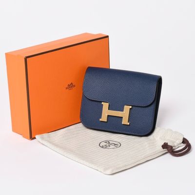 an image of a blue purse with a gold h on it