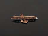 a gold and pearl broochle pin with a bird on it