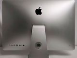 a silver apple computer sitting on a white table