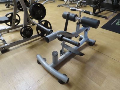a gym room with a row of exercise equipment on the floor