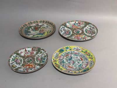 four chinese plates with floral designs on them sitting on a table