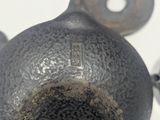 a hand holding a black vase with a hole in it
