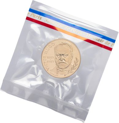 a close up of a coin in a plastic bag on a white background