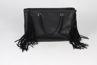 a black leather bag with fringes on the handle