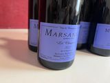 three bottles of wine are lined up on a table