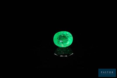 un gros plan d'une émeraude verte sur une surface noire