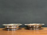 two silver plated bowls on a wooden table with a chalkboard in the background