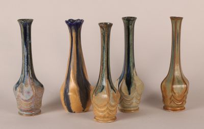 five different colored glass vases lined up in a row
