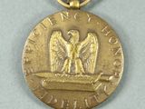 an old medal with a red ribbon and a gold eagle on it