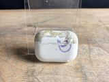 une boîte transparente contenant un petit objet blanc, posée sur une table en bois