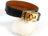 a close up of a black leather bracelet with a gold buckle