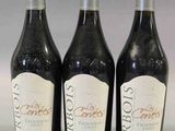 trois bouteilles de vin posées sur une table l'une à côté de l'autre