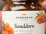 quelqu'un tient un pot de confiture contenant des oranges
